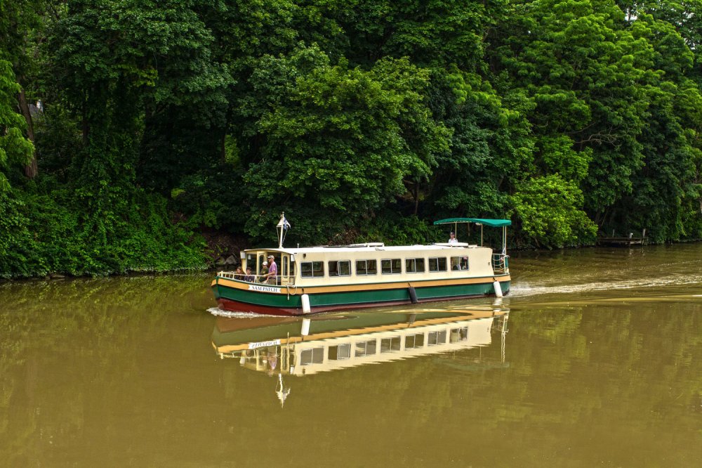 a bus traveling down a river next to a body of water