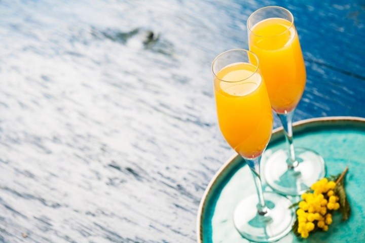 a glass of orange juice next to a cup of water