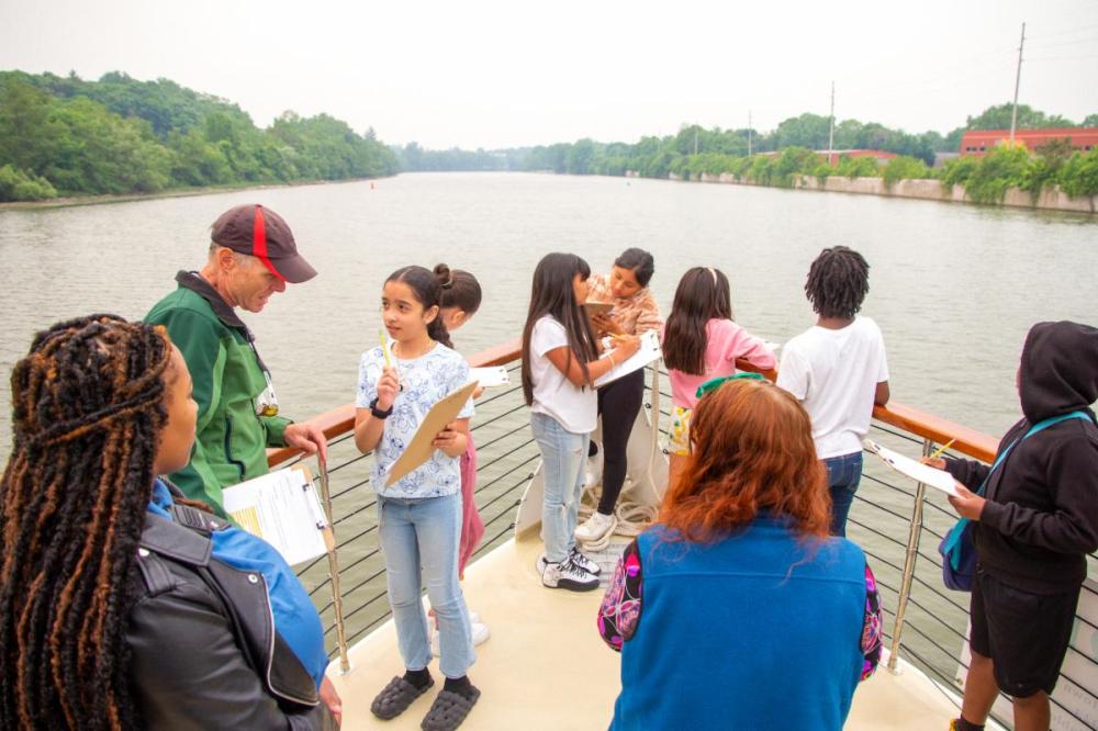 a group of people standing next to a body of water