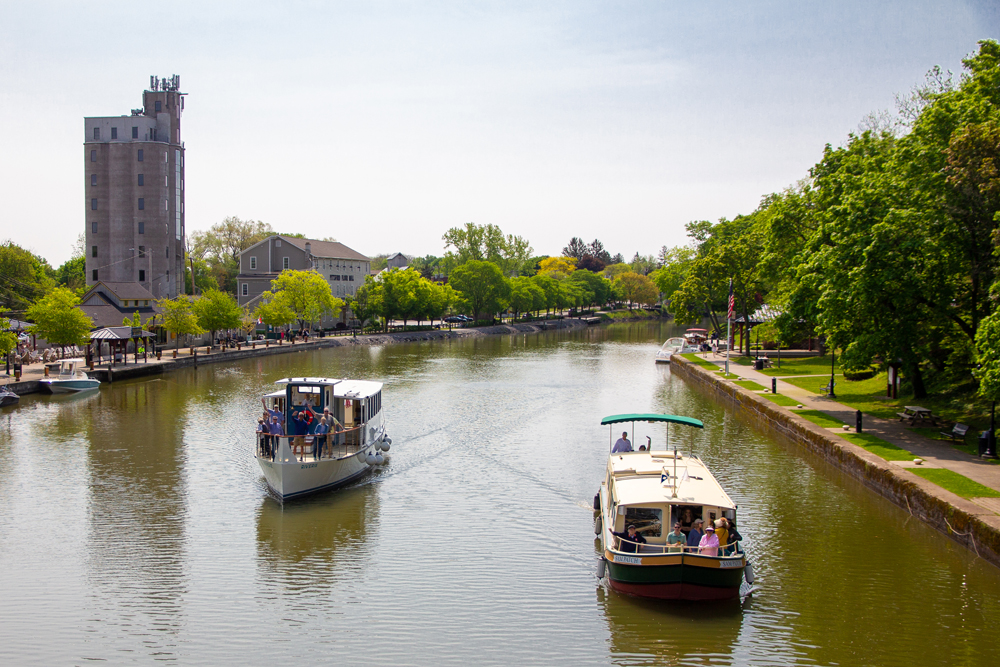 a boat traveling along a river next to a body of water
